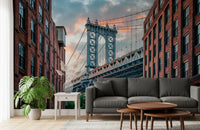 Manhattan Bridge Vista wallpaper mural of the bridge tower behind a grey sofa and round wood tables in a living room