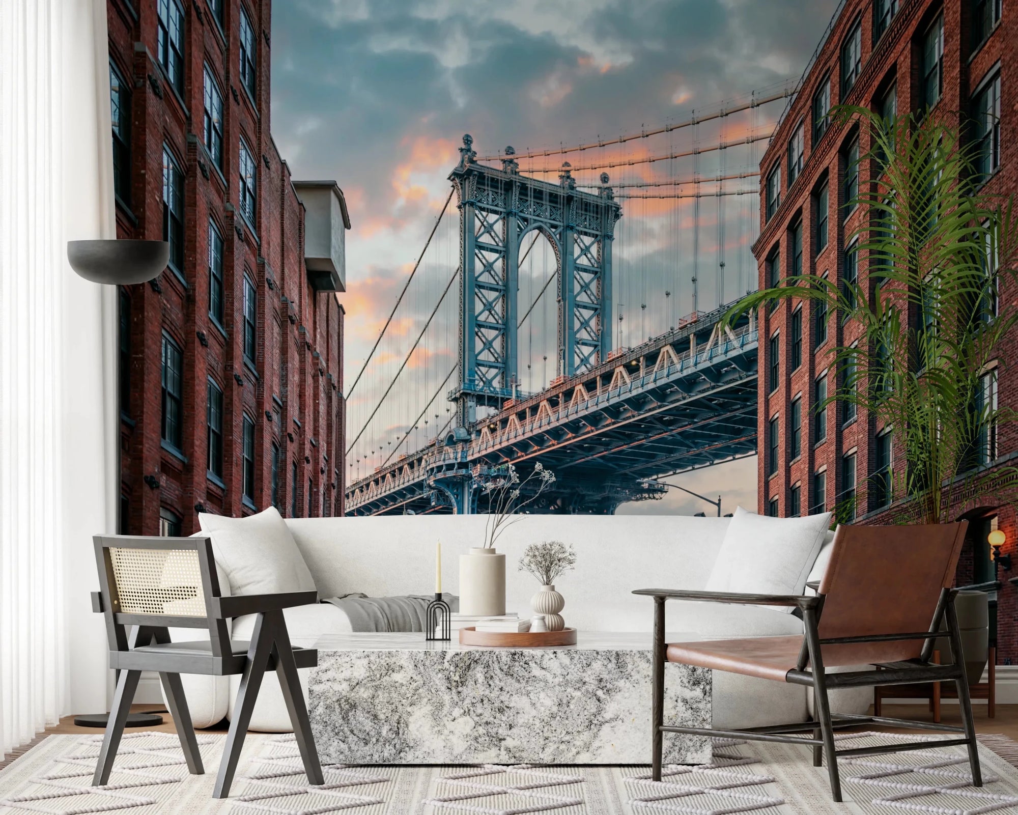Manhattan Bridge Vista wallpaper mural of the bridge tower between brick buildings behind a white sofa in a living room