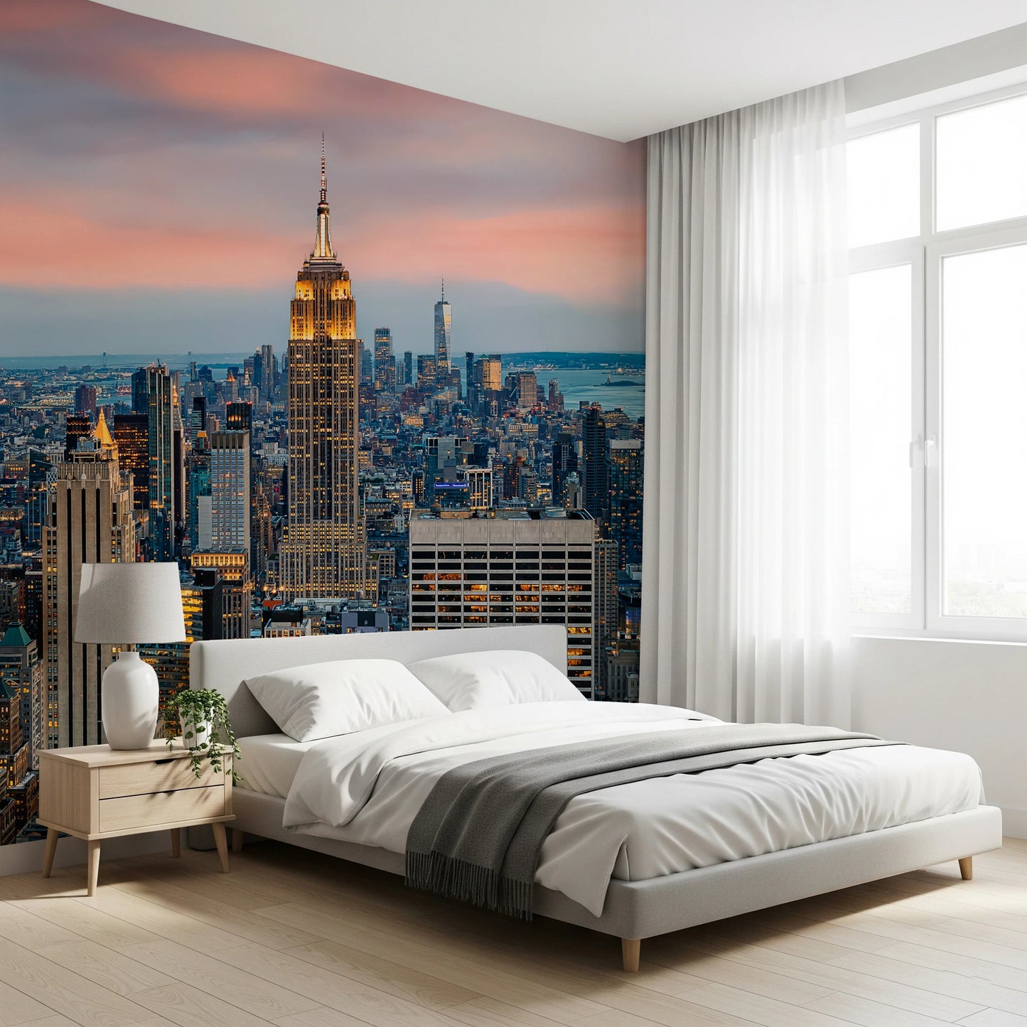Manhattan Dawn wallpaper mural with a pink dawn sky behind a white platform bed and wood nightstand