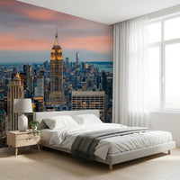 Manhattan Dawn wallpaper mural with a pink dawn sky behind a white platform bed and wood nightstand
