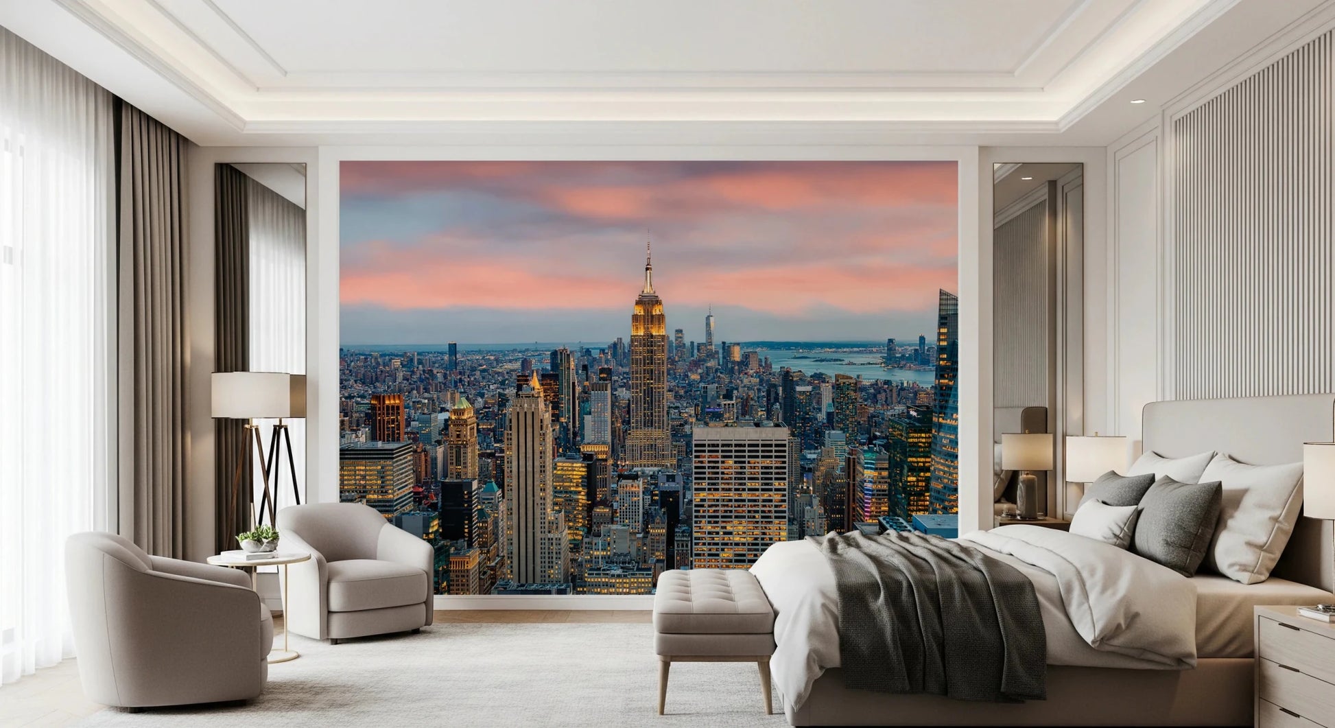 Manhattan Dawn wallpaper mural with a pink sunset sky behind a beige bed and two cream swivel chairs