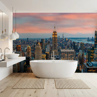 Manhattan Dawn wallpaper mural of the skyline behind a freestanding white bathtub in a bright bathroom