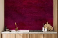 Maroon Watercolor wallpaper mural in deep magenta behind a wood kitchen counter with gold faucet and cooktop