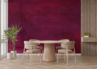 Maroon Watercolor wallpaper mural in rich maroon behind a round wood table and beige chairs in a modern dining room
