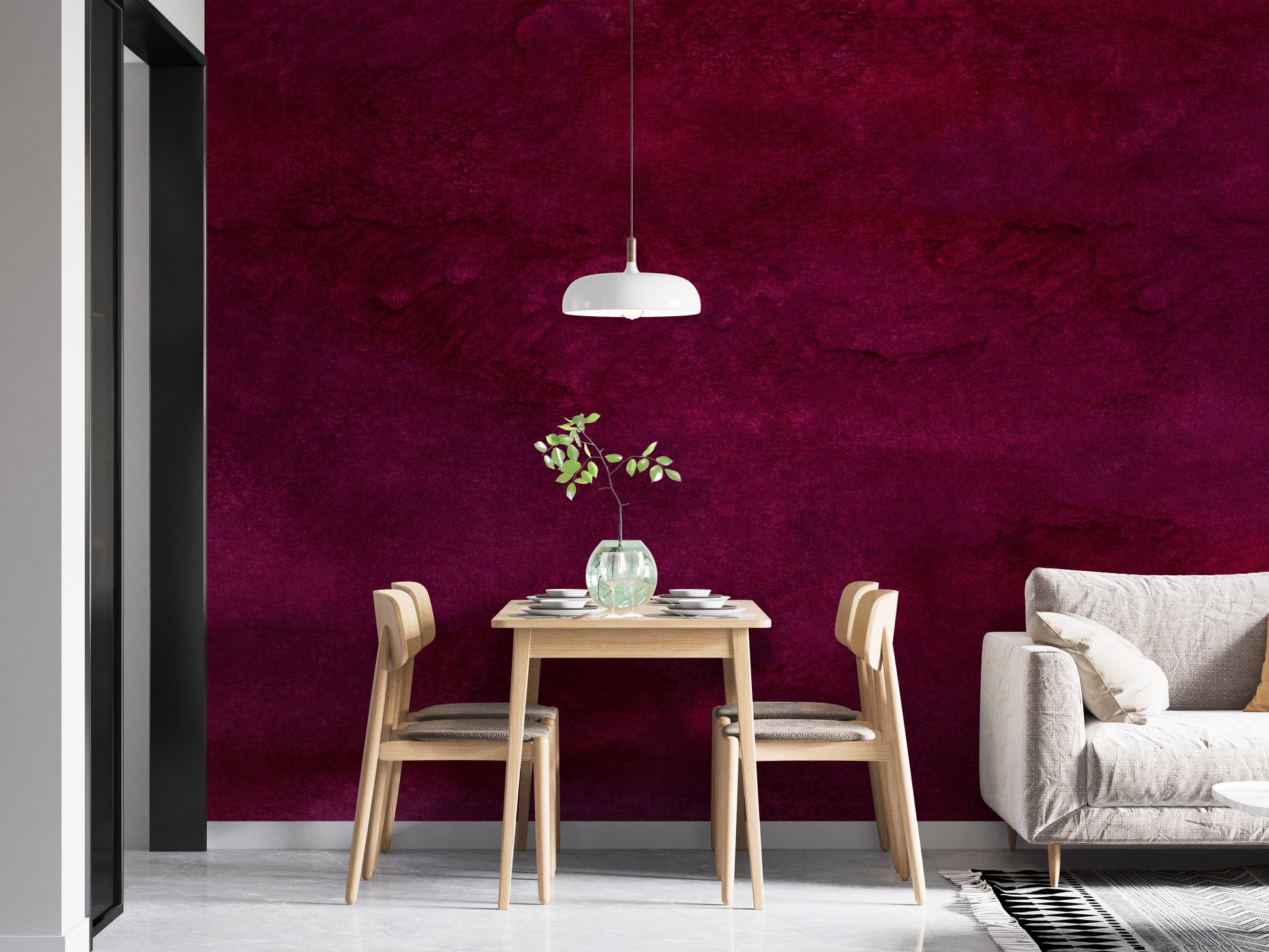 Maroon Watercolor wallpaper mural in deep magenta wash behind a light wood dining table and white sofa in a dining area