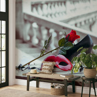 Masquerade Romance wallpaper mural with red mask and rose behind a wooden entryway bench, sun hat and potted plant