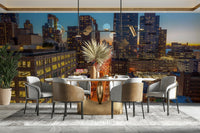The image shows a sweeping panoramic view of a modern metropolis as the sun sets.

