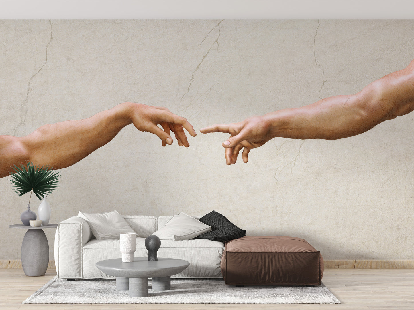 Michelangelos famous masterpiece wallpaper mural of reaching hands behind a white sofa and brown ottoman in a living room