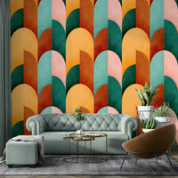 Mid Mod Geometry Sunburn wallpaper mural in retro arches behind a sage green tufted sofa in a bright living room