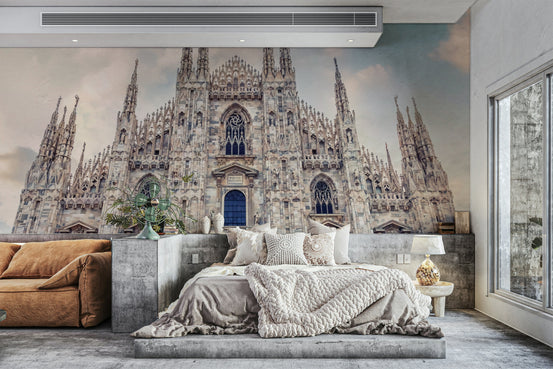 Milan Cathedral Majesty wallpaper mural behind a platform bed with gray bedding and a rust sofa in a bedroom