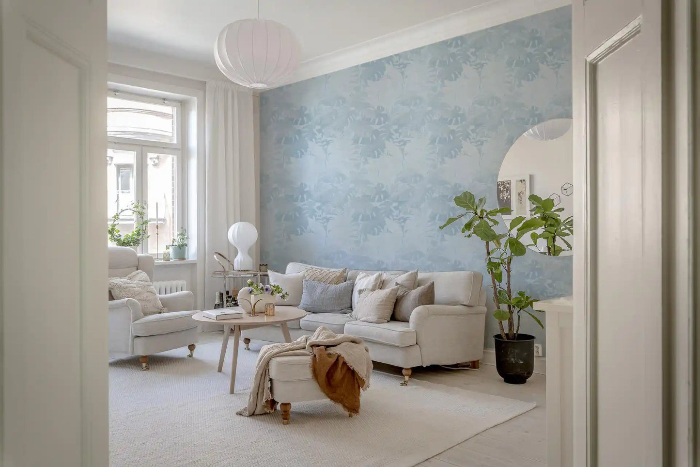 Pale blue botanical wallpaper with monstera leaf shapes
