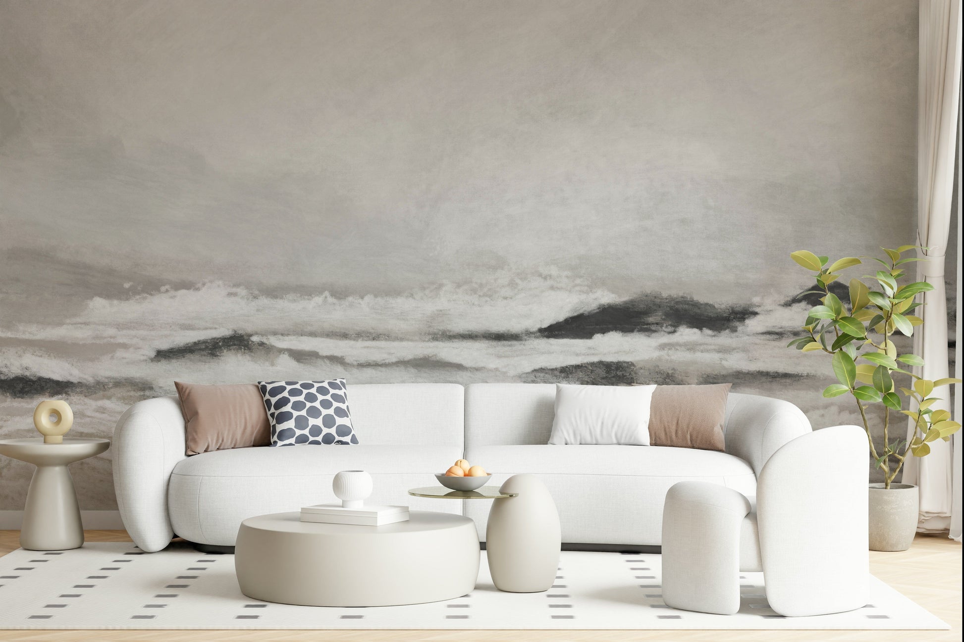 Misty Coast wallpaper mural of a hazy grey sea behind a white curved sofa with taupe cushions in a living room