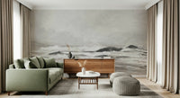 Misty Coast wallpaper mural in grey behind a sage green sofa and walnut sideboard in a curtained living room