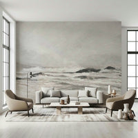 Misty Coast wallpaper mural of a pale stormy sea behind a grey sofa and two taupe armchairs in a bright living room