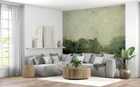 Misty Glen wallpaper mural of green woodland behind a grey sectional and round wood coffee table