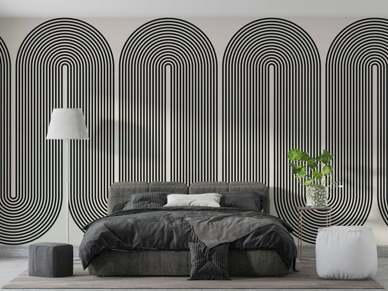Mod Arc wallpaper mural in black and cream concentric arches behind a gray bed and white floor lamp in a bedroom