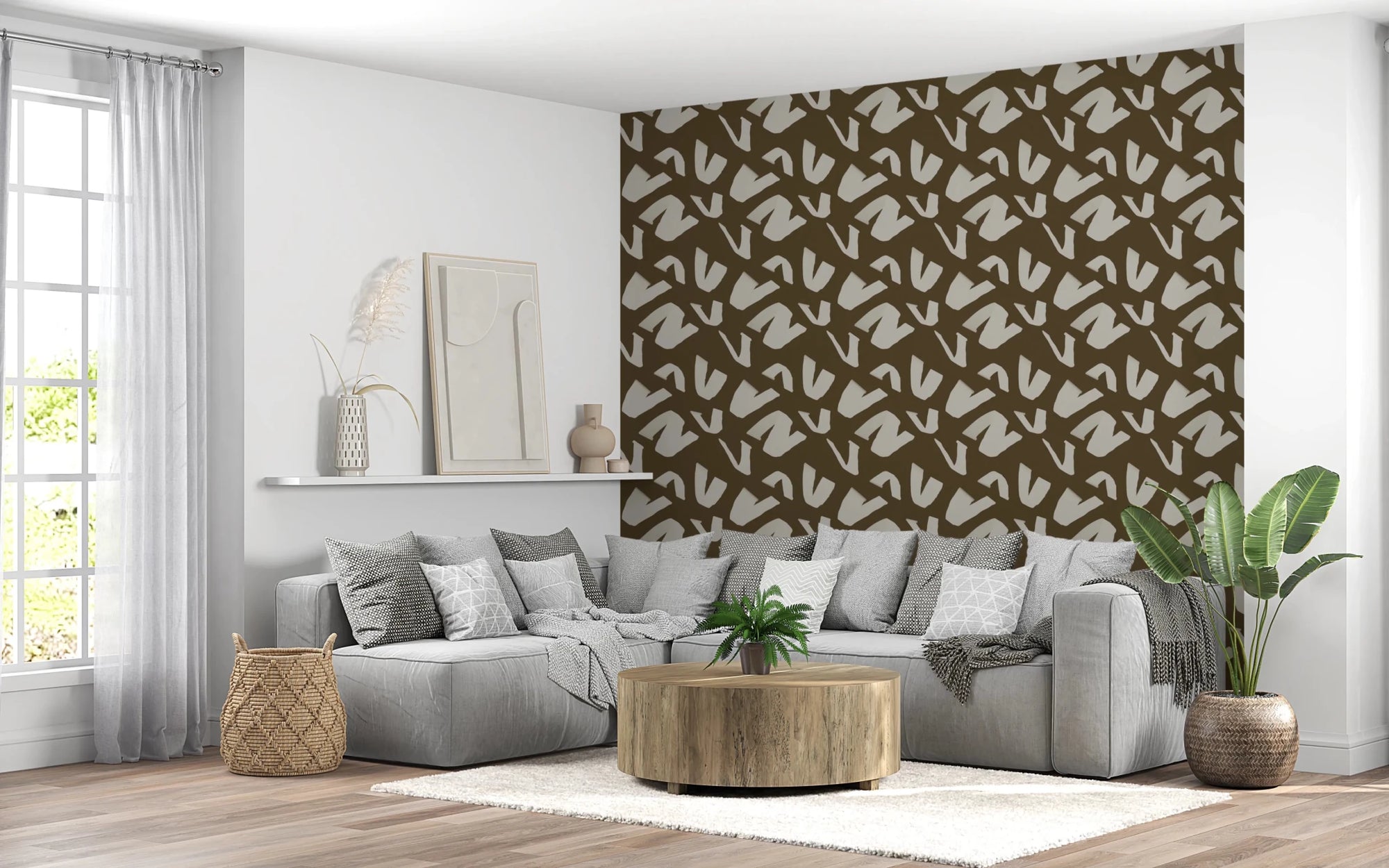 Modern Markings wallpaper of cream brushstroke shapes on brown behind a grey sectional sofa in a living room
