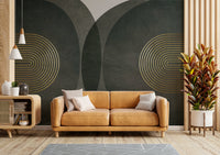 Modern Mid Century Charcoal Gold wallpaper mural with gold arches behind a tan leather sofa and croton plant in a living room