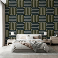 Modern Textured Signs Winter wallpaper in olive and slate geometric pattern behind a grey upholstered bed with twin lamps in a bedroom