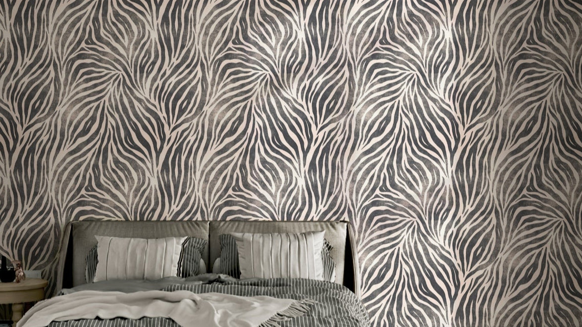 Mono Textured Boho Zebra Print wallpaper in a bedroom with grey stripes behind an upholstered bed and striped throw