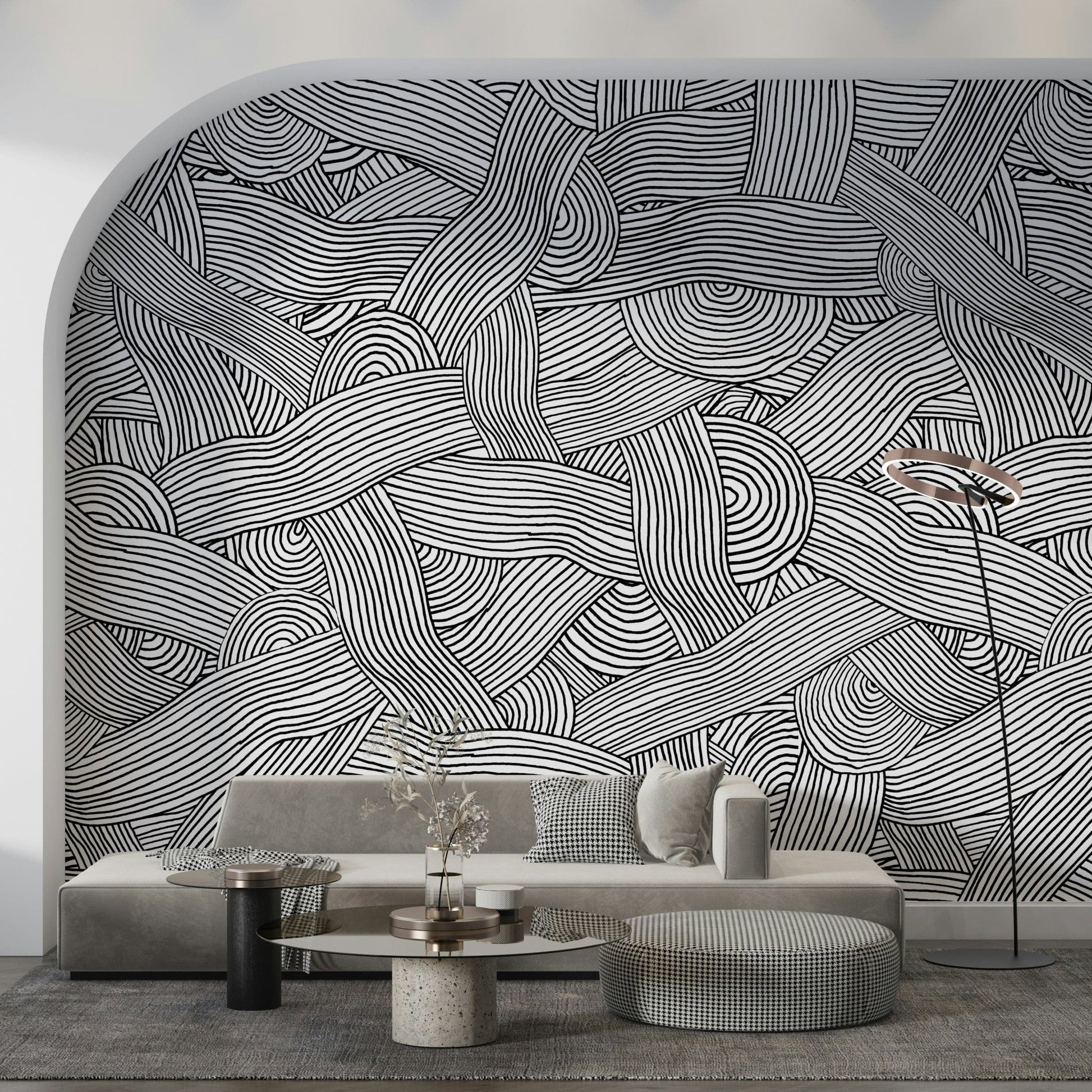Monochromatic Striped Maze wall mural in black and white on an arched wall behind a grey sofa