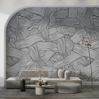 Monochromatic Striped Maze wall mural in black and white on an arched wall behind a grey sofa