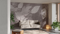 Monochrome Botanical Leaf wall mural with white leaves on taupe behind a beige two-seater sofa and lantern in a living room