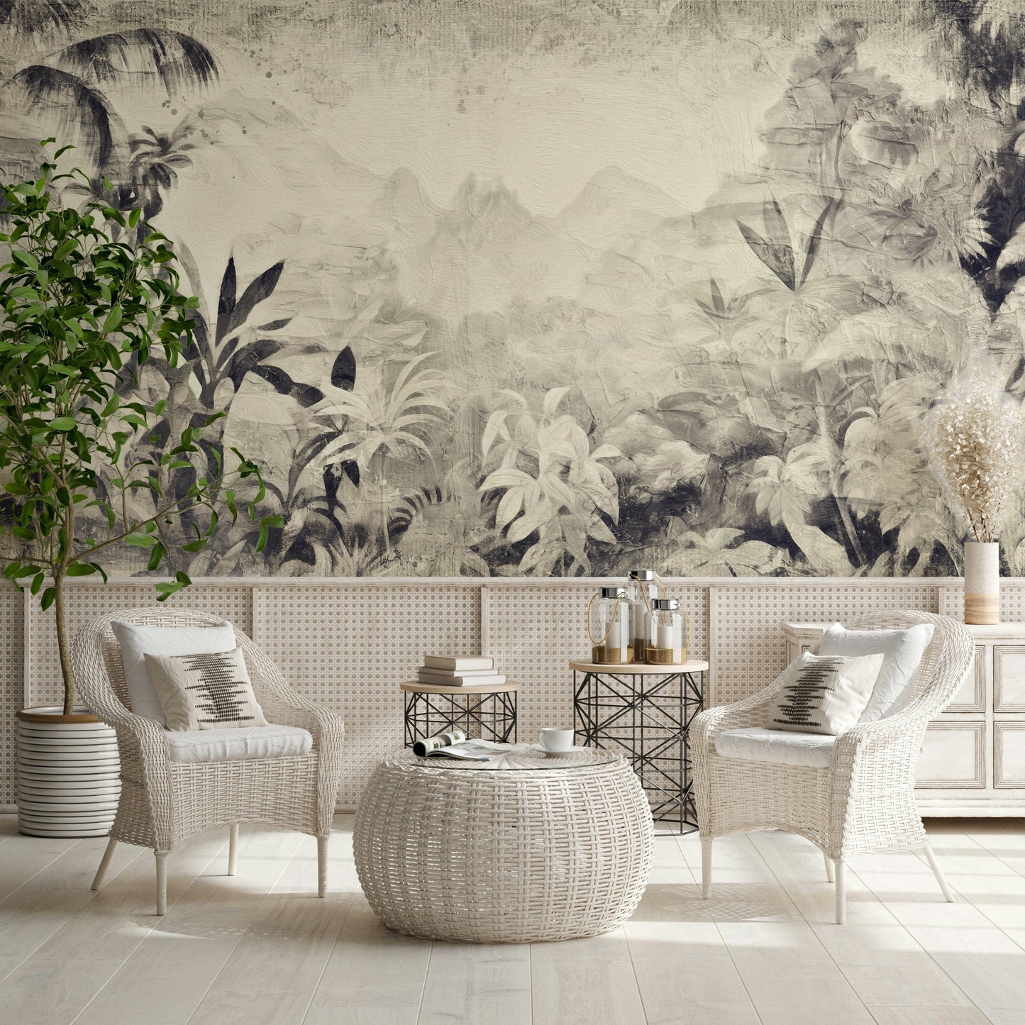 Monochrome Jungle Dream wallpaper mural in grey jungle behind two white wicker chairs and a woven pouf table