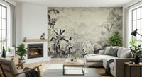 Monochrome Jungle Dream wallpaper mural in grey foliage beside a fireplace and grey sectional with leafy plants