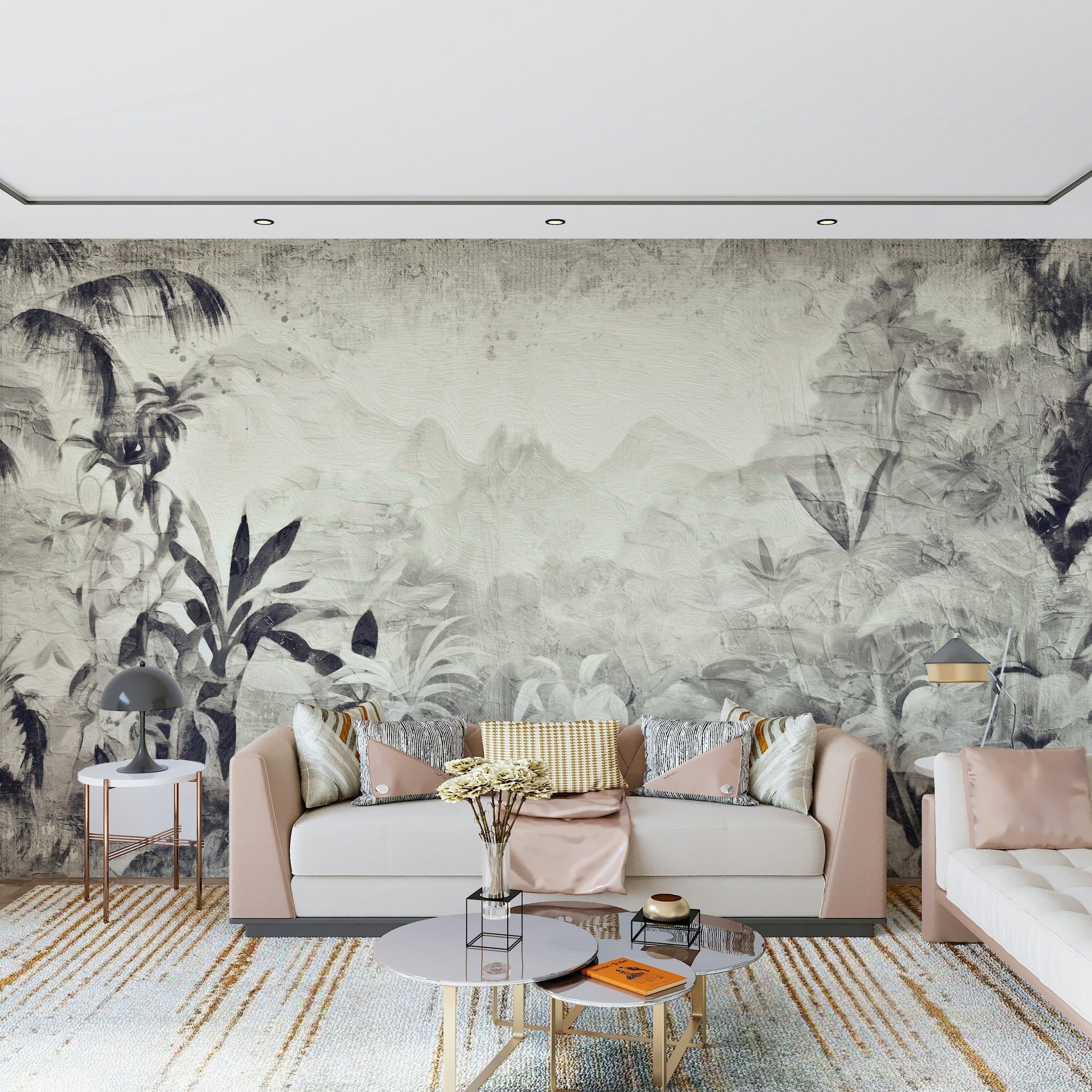 Monochrome Jungle Dream wallpaper mural of grey foliage behind a blush sofa with round tables and a gold-toned rug