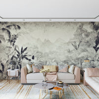 Monochrome Jungle Dream wallpaper mural of grey foliage behind a blush sofa with round tables and a gold-toned rug