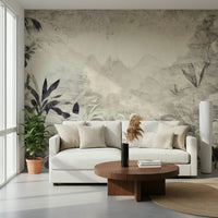 Monochrome Jungle Dream wallpaper mural of grey jungle leaves and mountains behind a white sofa and round wood table