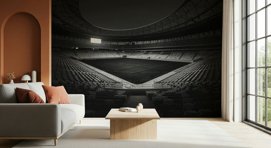 Stadium in Monochrome wallpaper mural of a black and white arena behind a grey sofa with terracotta cushions in a living room