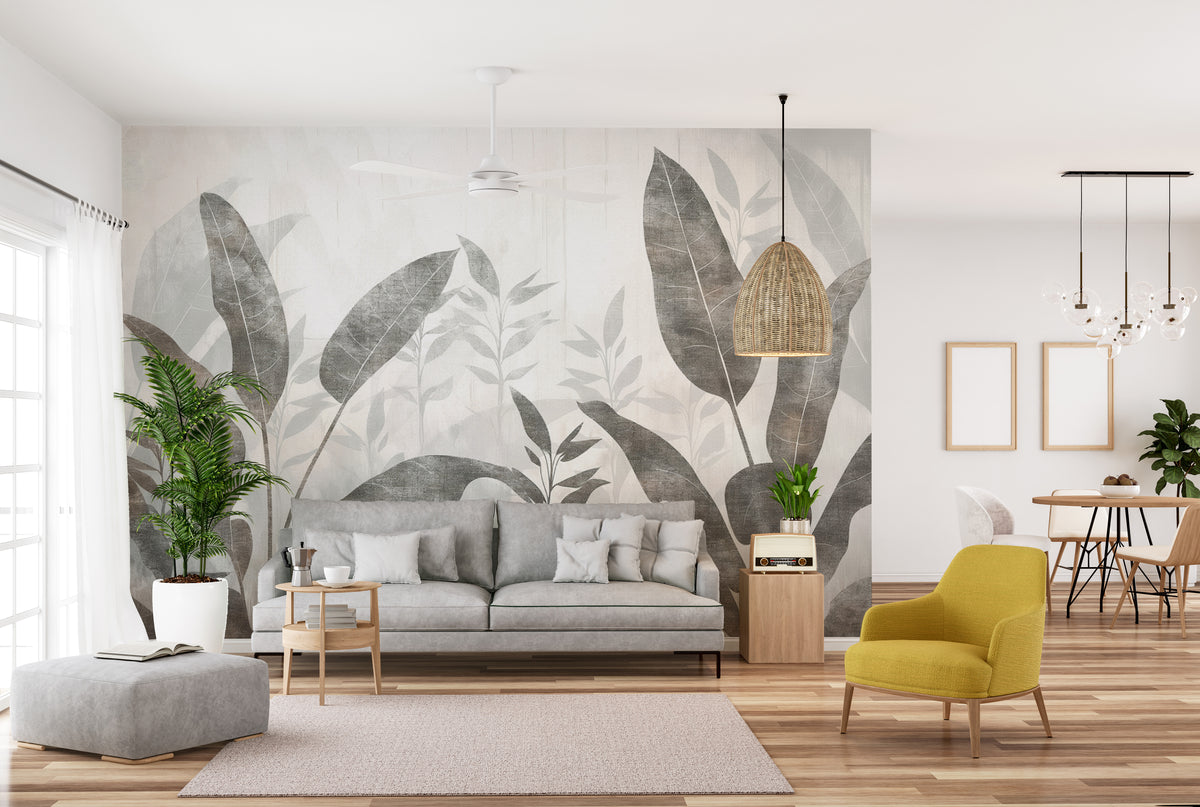 Monochrome Tropical Leaves wall mural in an open living room with a grey sofa and yellow accent chair