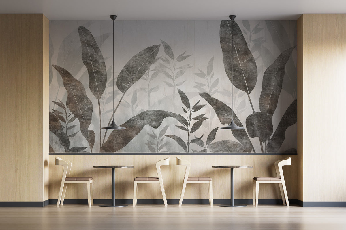 Monochrome Tropical Leaves wall mural behind pale wood chairs and bistro tables in a cafe seating nook