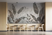 Monochrome Tropical Leaves wall mural behind pale wood chairs and bistro tables in a cafe seating nook