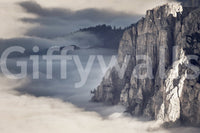 Mountain Majesty wallpaper mural close-up showing the grey cliff face rising above a sea of soft clouds