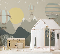 Mountains and Hot Air Balloons wallpaper in green with a yellow sun behind a wood house play tent and toy chest