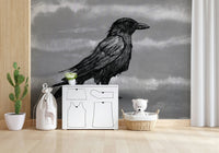 Mr Crow wall mural of a sketched raven on grey behind a rattan chair and crib in a nursery