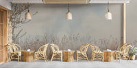 Natural Reeds wallpaper mural in soft beige and gray behind a row of rattan armchairs and tables in a cafe