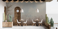 Natural Reeds wallpaper mural of misty beige grasses on gray behind white cafe chairs and wood tables