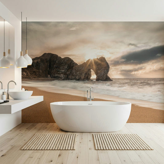 Nature's Gateway wallpaper mural of a sunset sea arch in a bathroom behind a freestanding white bathtub