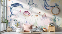 Nautical Creatures wall mural with dolphin and jellyfish above floor cushions and a wood nightstand in a kids room
