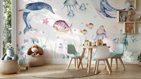Nautical Creatures wall mural behind a round play table with teal kids chairs and wood blocks on a jute rug
