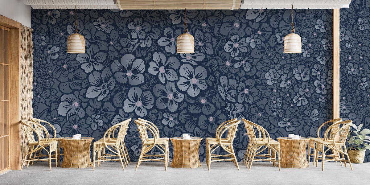 Navy Blue Garden Flower wallpaper mural behind wicker chairs and tables in a cafe seating area