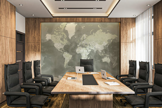 Neutral Green Watercolor World Map wallpaper mural in olive green behind a long wood table in a boardroom