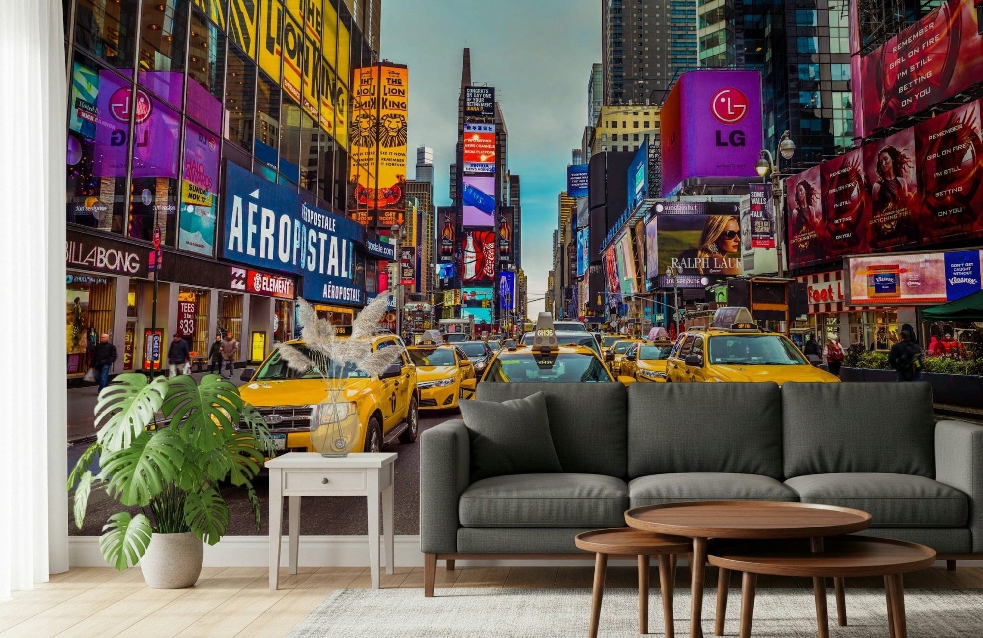 New York's Urban Pulse mural of yellow cabs in Times Square behind a grey sofa and monstera plant