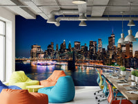 Night Metropolis wallpaper mural of the lit skyline behind colorful bean bag chairs and laptop desks in a bright office lounge