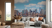 NYC Bridge Vista wallpaper mural of the Manhattan skyline behind a white sofa and rattan table in a living room