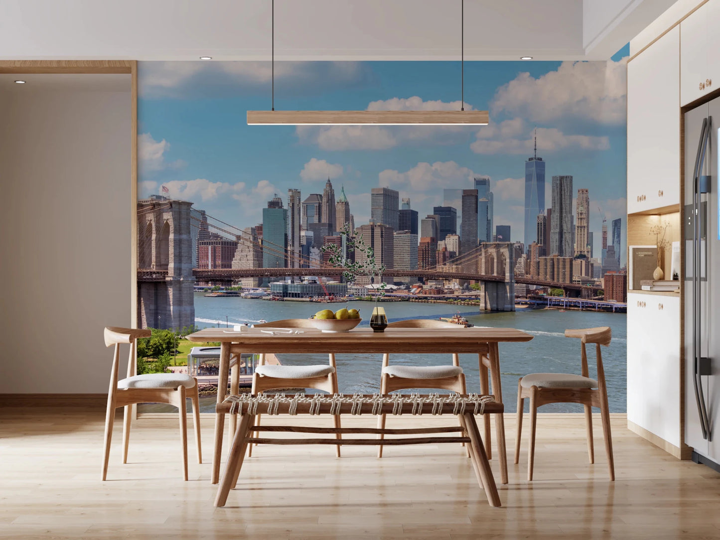 NYC Bridge Vista wallpaper mural of the Brooklyn Bridge behind a wooden dining table and chairs in a bright kitchen